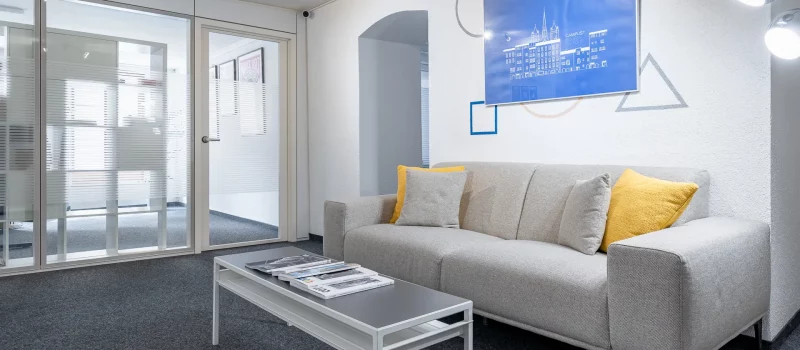 espace lounge commun avec canapé et tableau pour un espace de domiciliation et adresse professionnelle à Genève